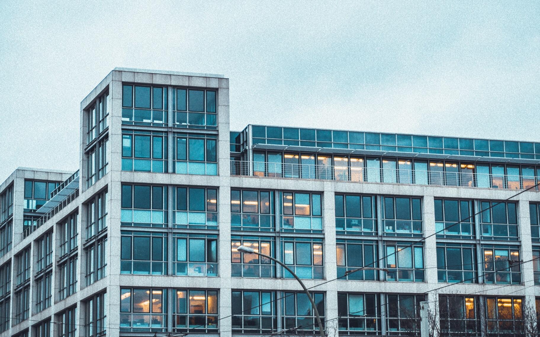 Zeitgenössische Unternehmenszentrale mit Glasfassade und beleuchteten Büroetagen